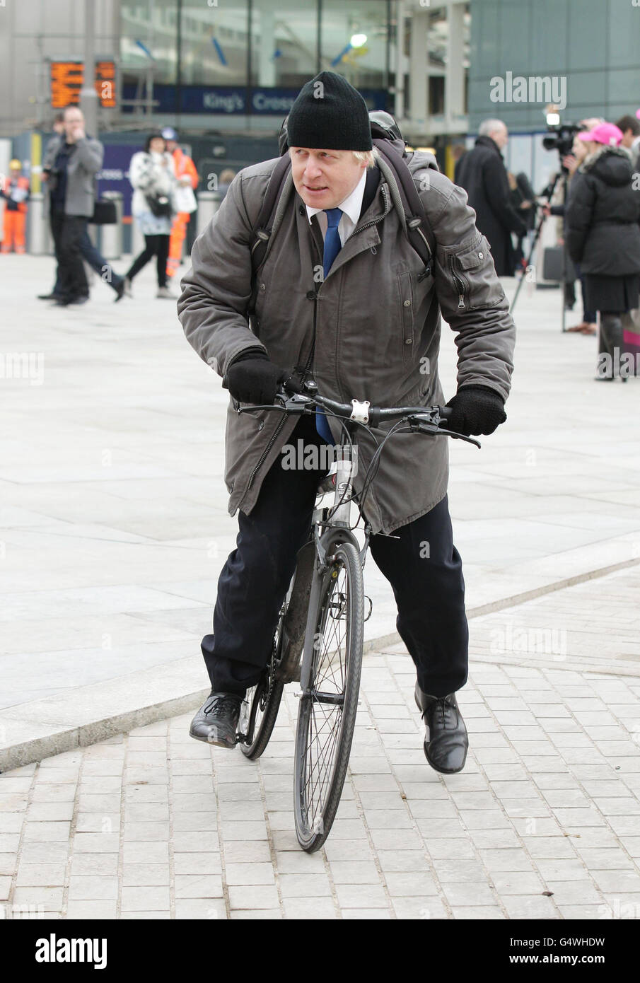 Boris Johnson verlässt sein Fahrrad nach der Teilnahme an der Veranstaltung Get Ahead of the Games - Plane Your Travel in 2012, einer Initiative, um Pendlern und Reisenden in London und Großbritannien zu erklären, wie Verkehrsnetze während der Spielzeit funktionieren und wie sie ihre Reise planen sollten, Am Deutschen Gymnasium, Pancras Way, London. Stockfoto
