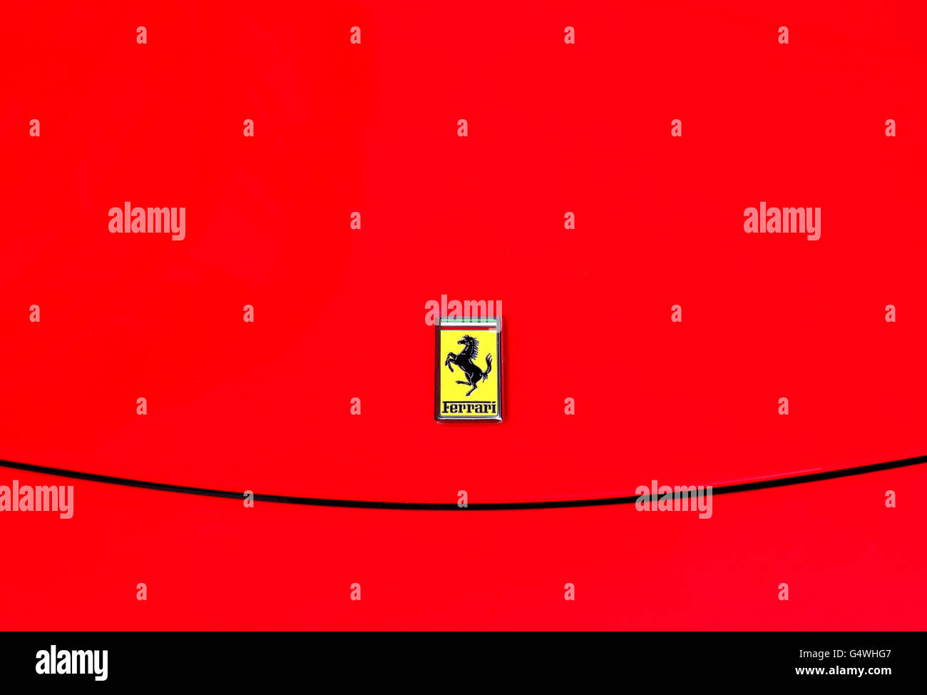 die weltweit bekannte Ferrari-Logo auf einem roten Ferrari-Sportwagen in einer öffentlichen Straße geparkt. Stockfoto