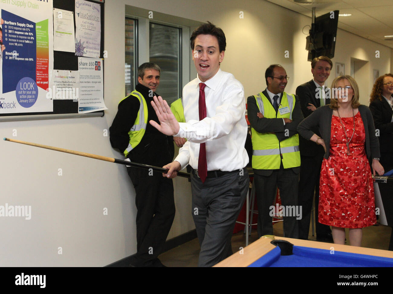 Labour-Chef Ed Miliband spielt Pool, während die schottische Schattensekretärin Margaret Curran bei einem Besuch in einem Co-op-Vertriebszentrum in North Lanarkshire anschaut (rotes Kleid), als er versprach, dass seine Partei vor der Abstimmung über die Unabhängigkeit "von Zehen zu Zehen" mit Schottlands erstem Minister kämpfen wird. Stockfoto