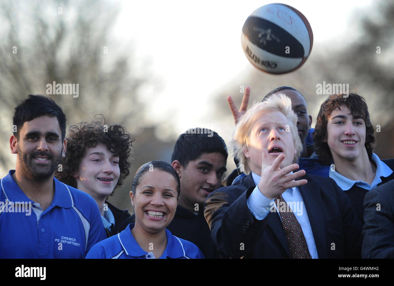 Der Londoner Bürgermeister Boris Johnson wirft Bälle in die Luft mit Schülern der Chiswick Community School im Westen Londons, wo er und der Londoner 2012-Vorsitzende Lord Coe der Schule mitteilten, wie viele olympische Tickets sie über das Londoner Ticketshare-Programm 2012 erhalten würden. Stockfoto