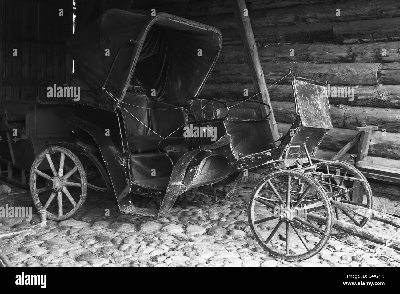 Leere Vintage schwarze Trainer steht im ländlichen Garage, schwarz / weiß Foto Stockfoto