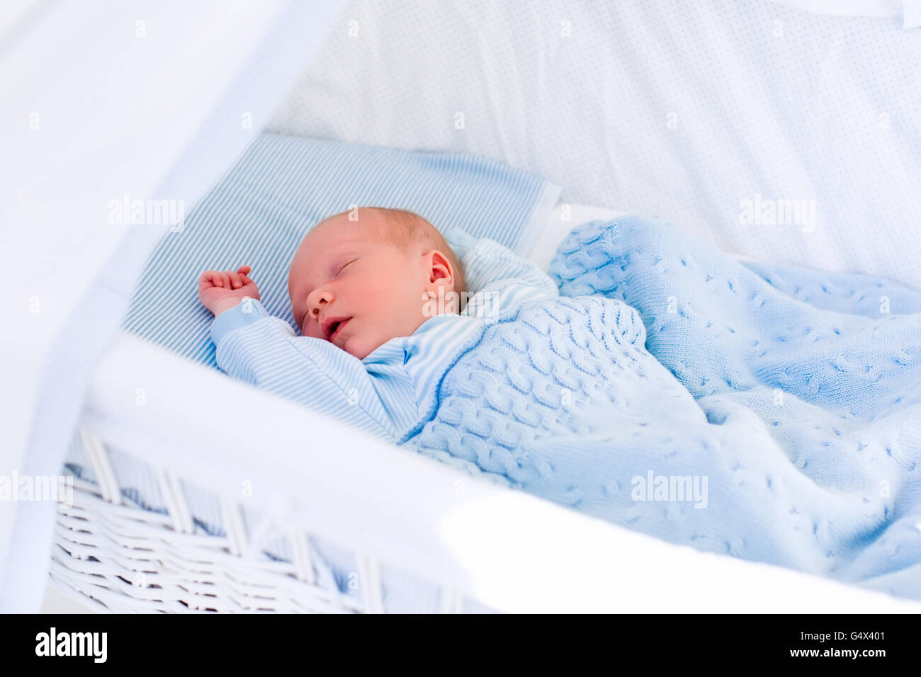 Neugeborenes Baby junge im Bett. Neues Kind geboren, unter einer blauen gestrickte Decke schlafen. Kinder schlafen. Bettwäsche für Kinder. Stockfoto