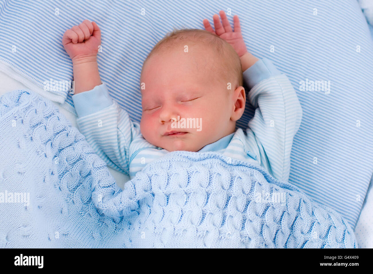 Neugeborenes Baby junge im Bett. Neues Kind geboren, unter einer blauen gestrickte Decke schlafen. Kinder schlafen. Bettwäsche für Kinder. Stockfoto