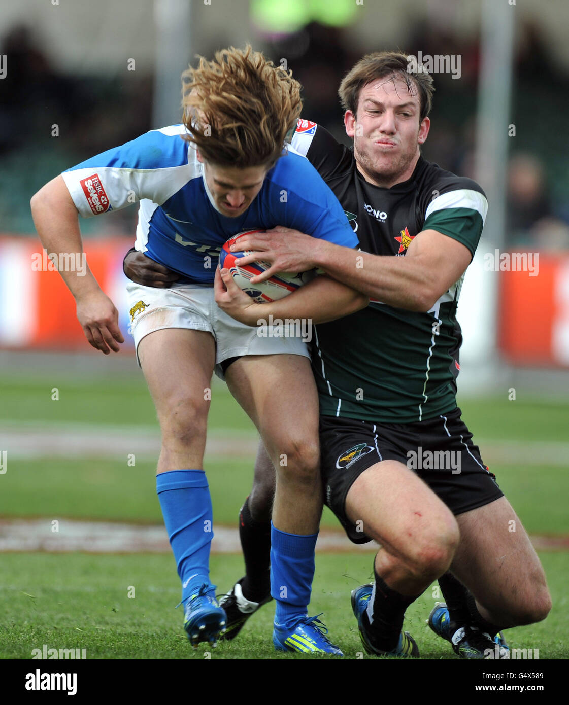 Argentiniens Agustin Migliore wird von Simbabwes Justine Coles während der Glasgow Sevens im Scotstoun Stadium in Glasgow angegangen. Stockfoto