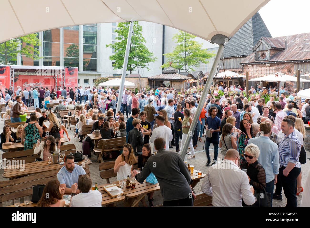 Nachtschwärmer genießen Sie die Atmosphäre des Biergartens im Oast House Restaurant und der Bar im Spinningfields Bereich von Manchester. Stockfoto