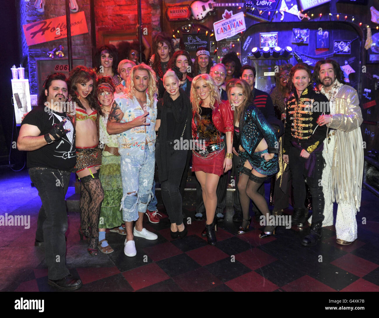 Kimberly Wyatt (vorne, fünfte links) und Adam Garcia (Mitte, vierte rechts) treffen im Shaftesbury Theatre, London, auf die Darsteller von Rock of Ages, darunter Shayne ward (vierte links) und Justin Lee Collins (rechts). Stockfoto