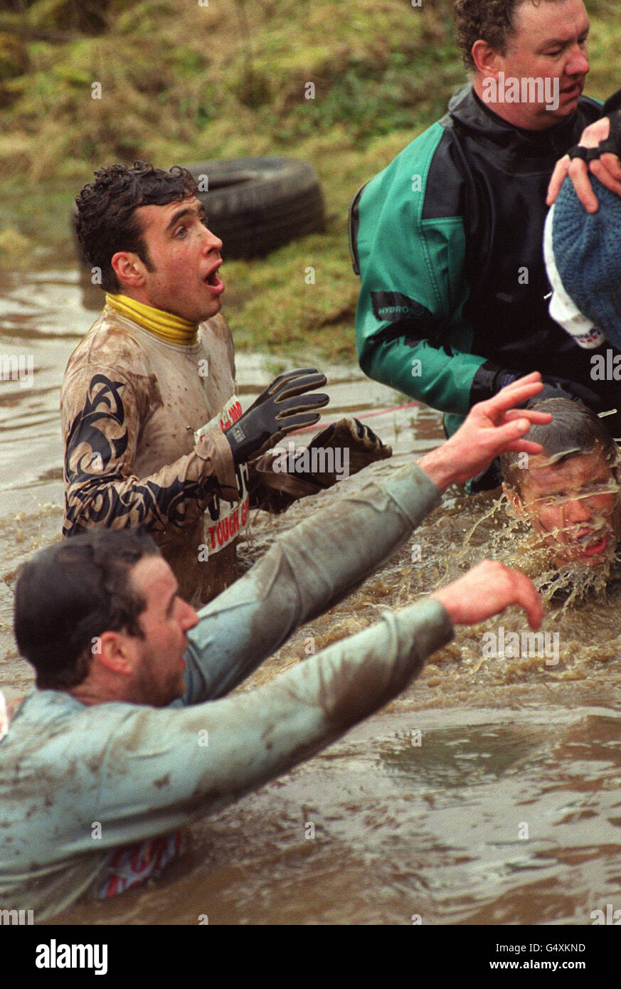 Teilnehmer des harten Guy 2000 Langstreckenrennens für wohltätige Zwecke in Staffordshire. Der gewundene Kurs beinhaltet ein elektrifiziertes Kletternetz, eiskalte Unterwasserschwimmen und eine Nachstellung der Dünkirchen-Landungen. * Michael Green, 44, aus Groby, in der Nähe von Leicester, starb im Krankenhaus nach einem Verdacht auf Herzinfarkt beim Rennen. Er hatte etwa drei Viertel der sieben-Meilen-Kurs abgeschlossen, bevor sie sich über Kälte beschwert. Stockfoto
