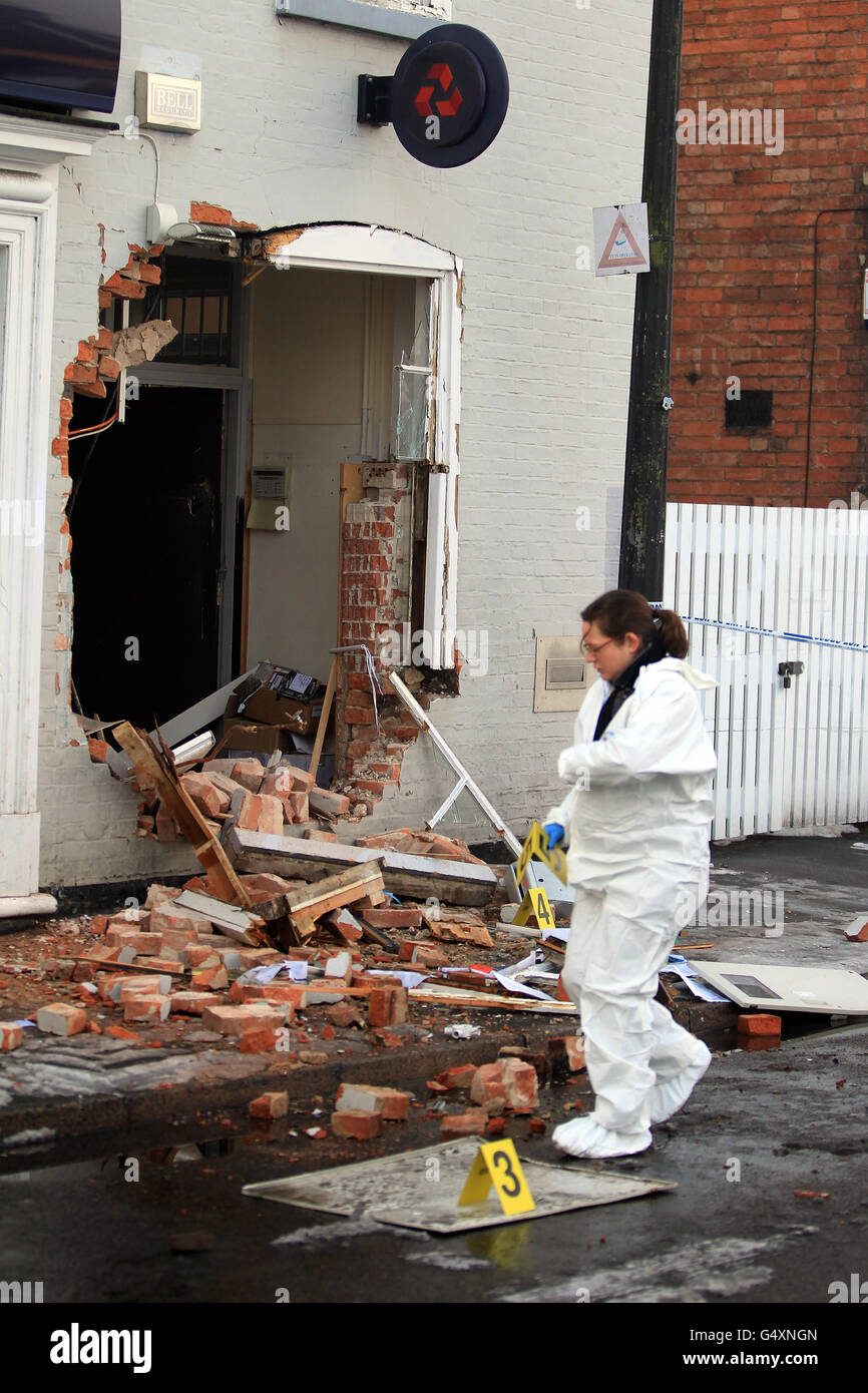 Ein Kriminalbeamter sammelt Beweise vor einer NatWest-Bank in der kleinen Marktstadt Bingham, Nottinghamshire, wo heute Morgen Diebe einen Traktor benutzten, um die Geldautomaten der Bank von der Wand zu ziehen. Stockfoto