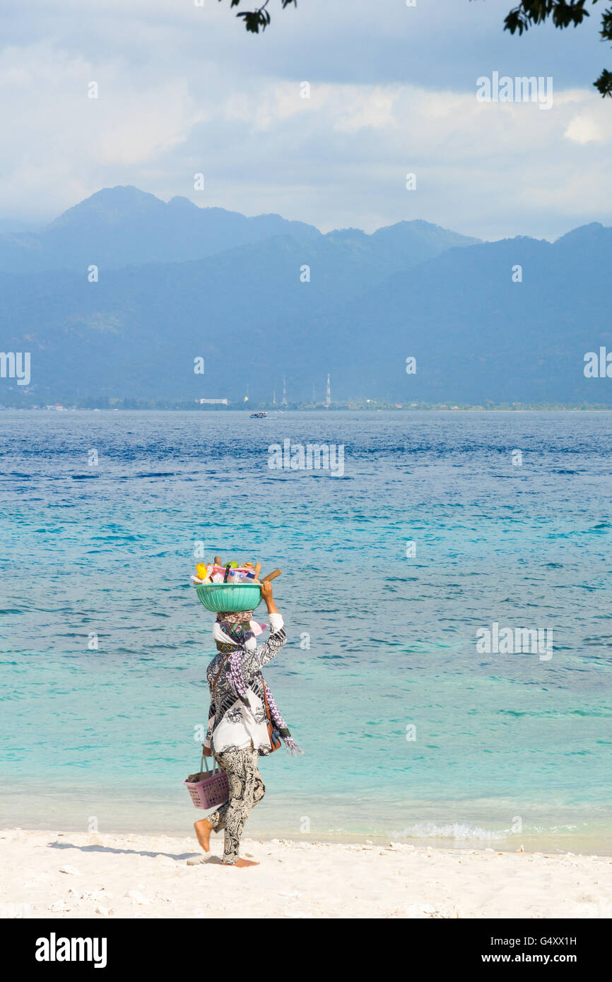 Nusa Tenggara Barat, Indonesien Lombok Utara, auf der Insel von Pulau Gili Meno, Frau mit Korb auf dem Kopf am Strand Stockfoto