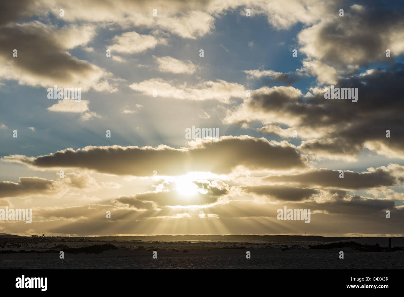 Spanien, Kanarische Inseln, Fuerteventura, Sonnenuntergang scheint durch die Wolken auf der spanischen Insel Fuerteventura Stockfoto