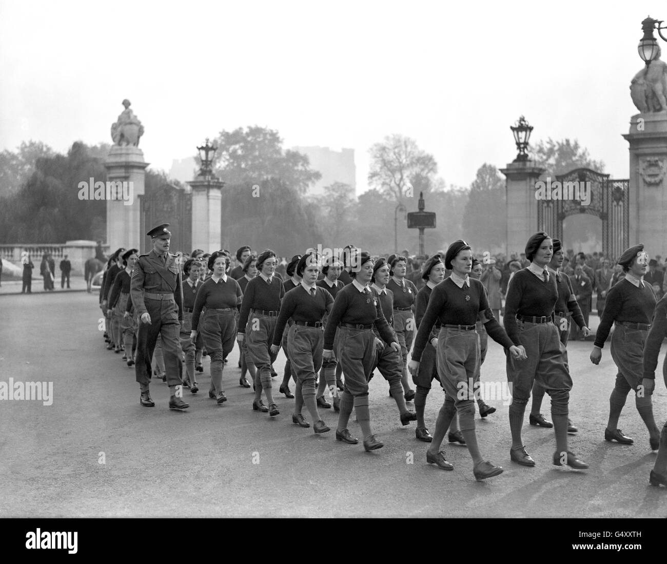 In ihrer Uniform aus grünen und Cord-Hosen marschieren 500 Mitglieder der aufgelöste Frauenlandarmee von der Kaserne Wellingtons zum Buckingham Palace, um von Königin Elizabeth (später Queen Mother) ihre Abschiedsinspektion zu machen. Stockfoto