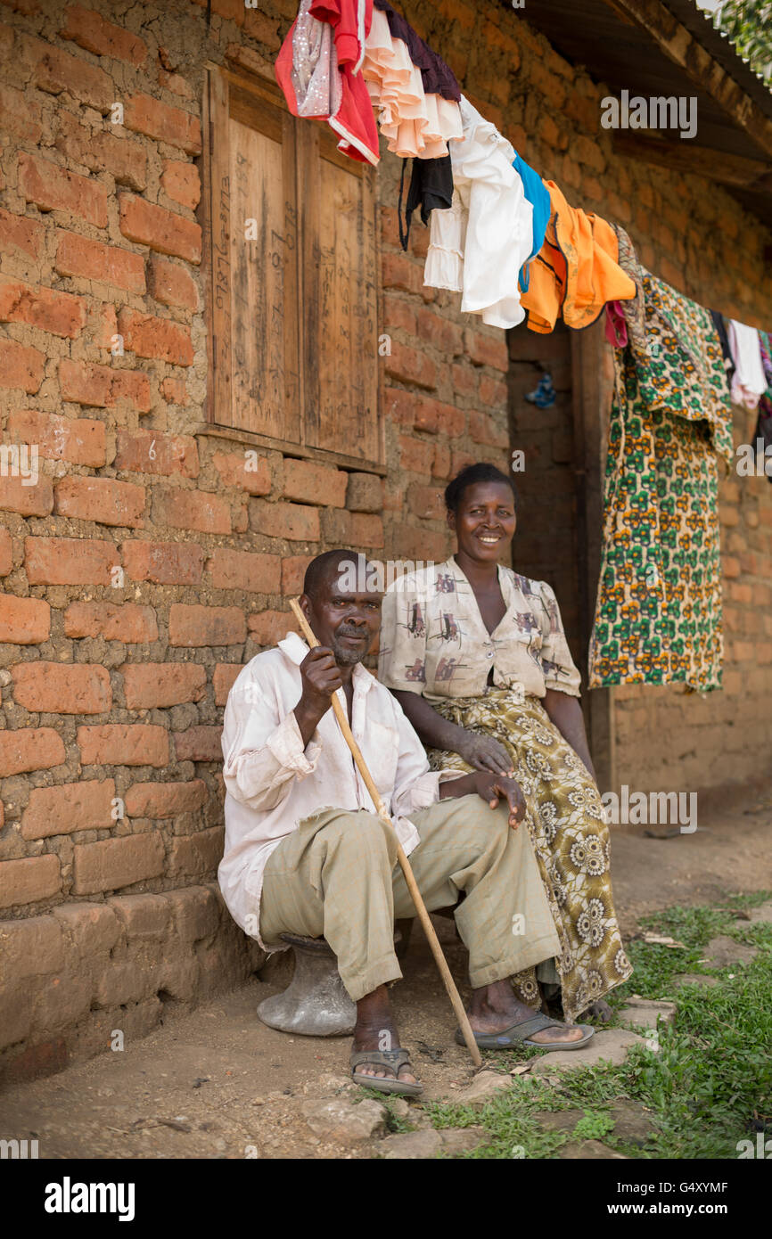 Mann und Frau sitzen vor ihrem Haus in Kasese District, Uganda, Ostafrika. Stockfoto