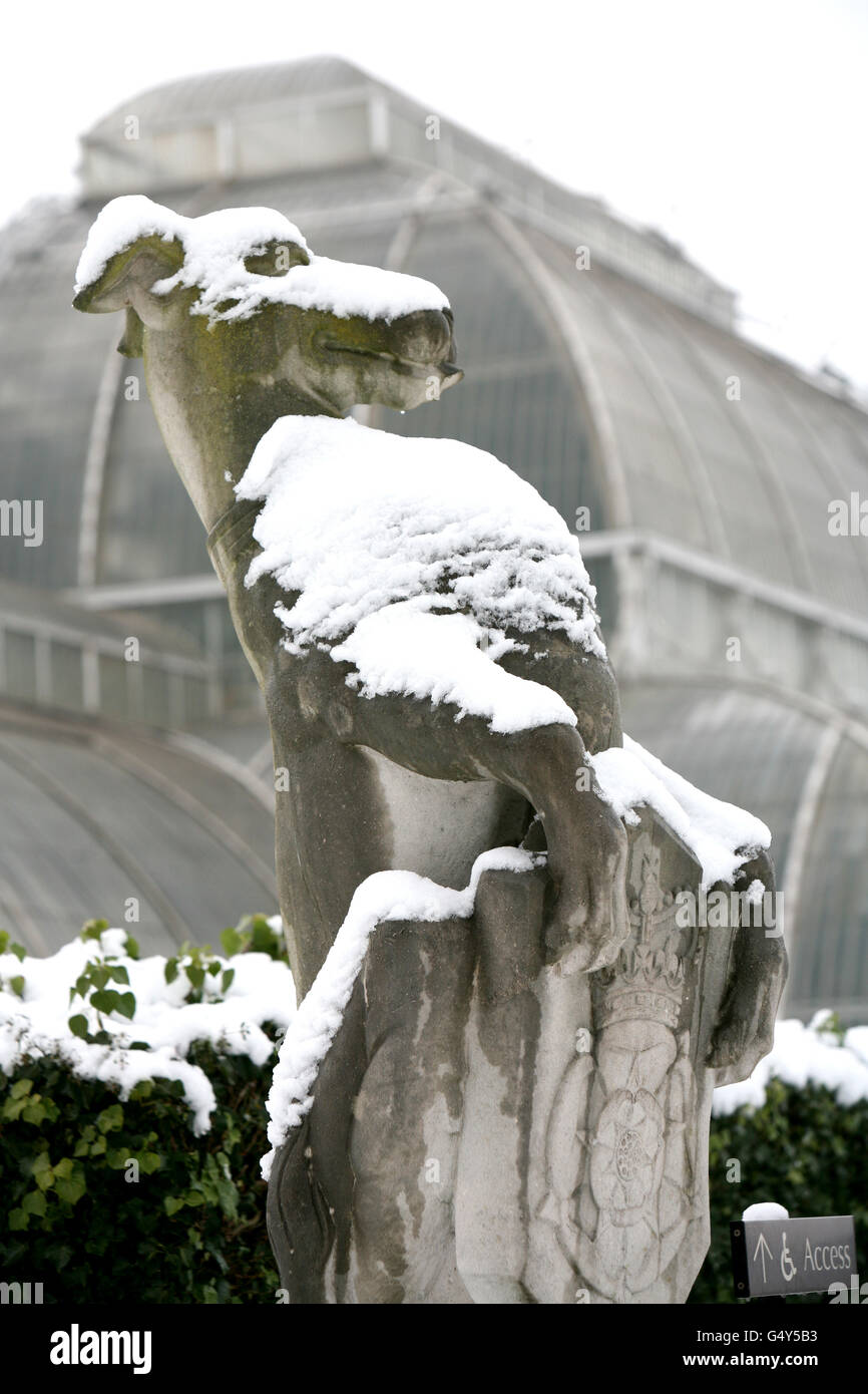 Eine schneebedeckte Statue steht Wache über dem Palm House in den Royal Botanical Gardens in Kew, West London, da ein großer Teil Großbritanniens zu einer Schneedecke aufwachte, nachdem der große Frost Deponien von bis zu 16 cm, geerdete Flugzeuge und Straßen- und Bahnstörungen verursachte. Stockfoto