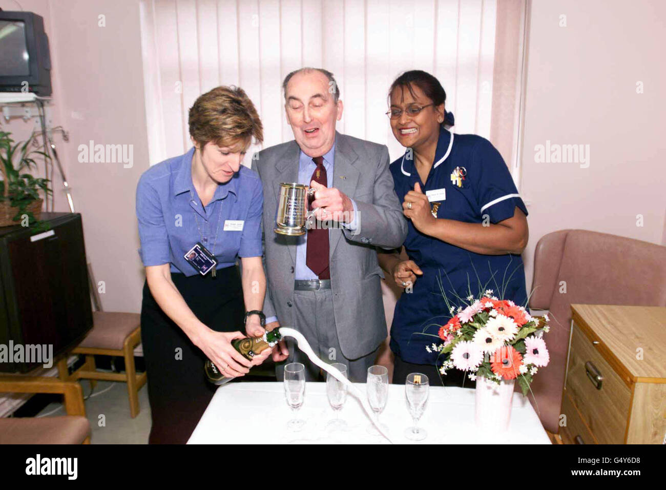 Derrick Morris (69), pensionierter Hafenmann von Swansea, feiert den 20. Jahrestag seiner Herztransplantation im Harefield Hospital, Middlesex. Mit ihm sind die Senior Nurse Manager Bridget Jansen (links) und Schwester Sherrie M. Panther. * Herr Morris wird in diesem Monat Europas am längsten überlebender Herztransplantationspatient. Sein neues Herz wurde vor zwanzig Jahren, zu Beginn des Transplantationsprogramms des Krankenhauses, von Prof. Yacoub in Harefield implantiert. Stockfoto