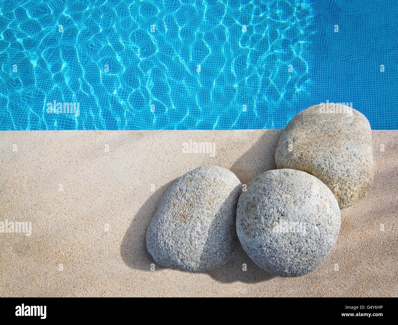 Schwimmbad-Hintergrund mit Beton, Steinen und blauen Kacheln in einer Kurve. Mallorca, Spanien. Stockfoto