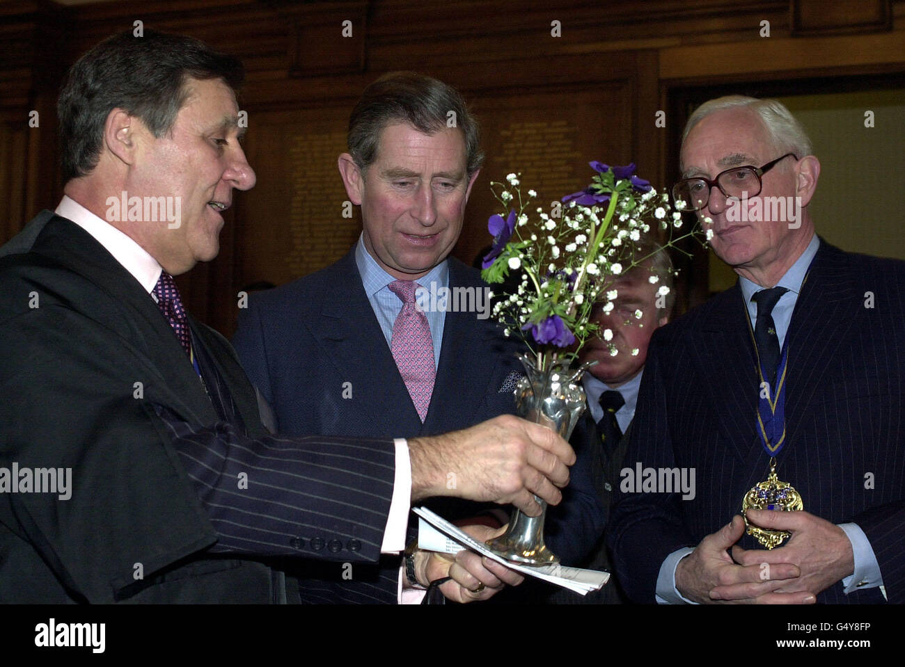 Der Prinz von Wales wird bei der Eröffnung der Millennium Pewter Collection in der Pewterer Hall in London von dem Clerk of the Worshipful Company of Pewterer (WCP) Anthony Steiner (links) und dem Master of the WCP William Grant eine Jugendstilvase gezeigt. *die Vase im Jugendstil basiert auf einem Design, das in allen staatlichen Räumen der Titanic verwendet wurde. Stockfoto