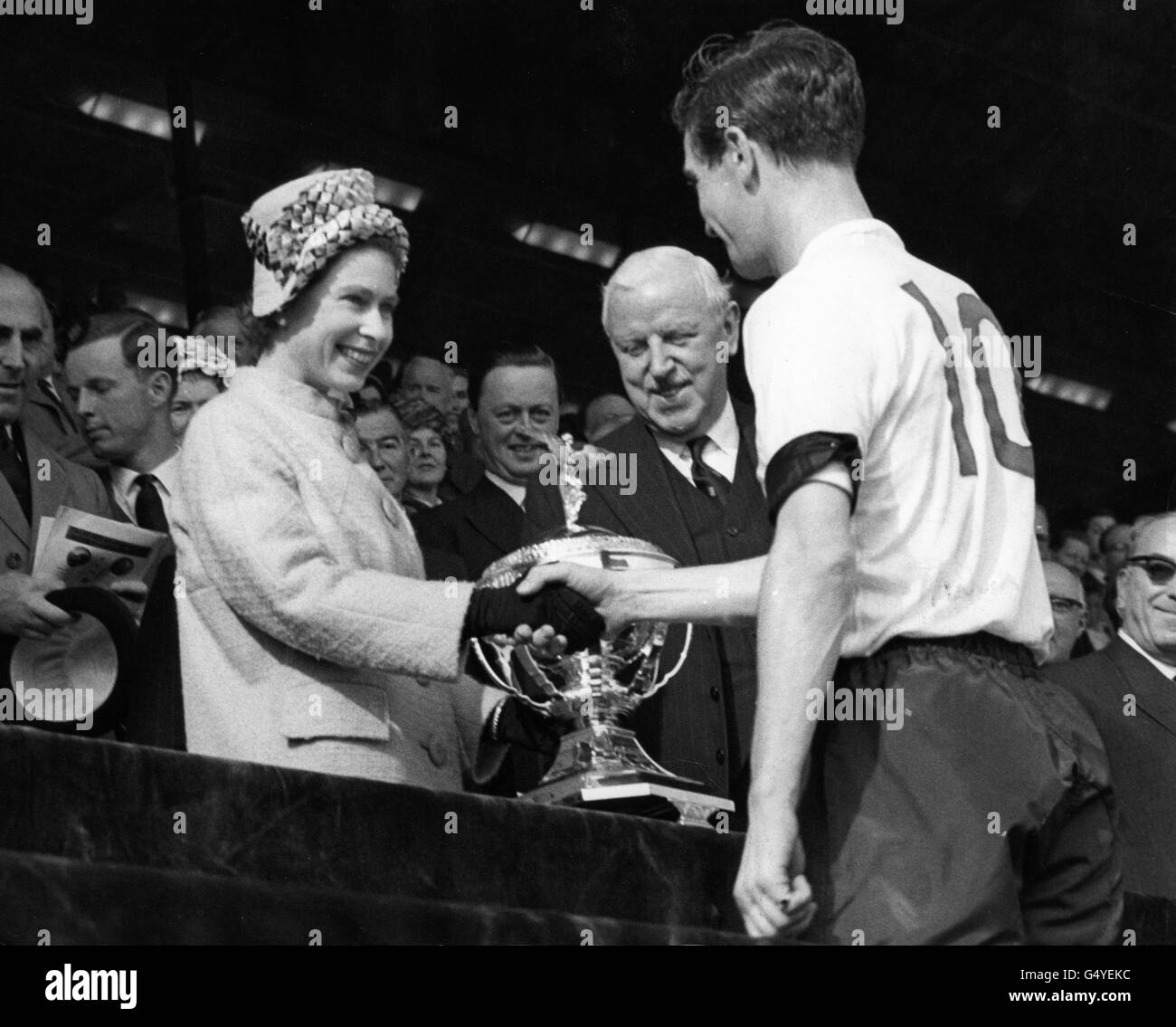 Queen Elizabeth II überreicht die International Championship Trophy an den englischen Kapitän Johnny Haynes. Stockfoto