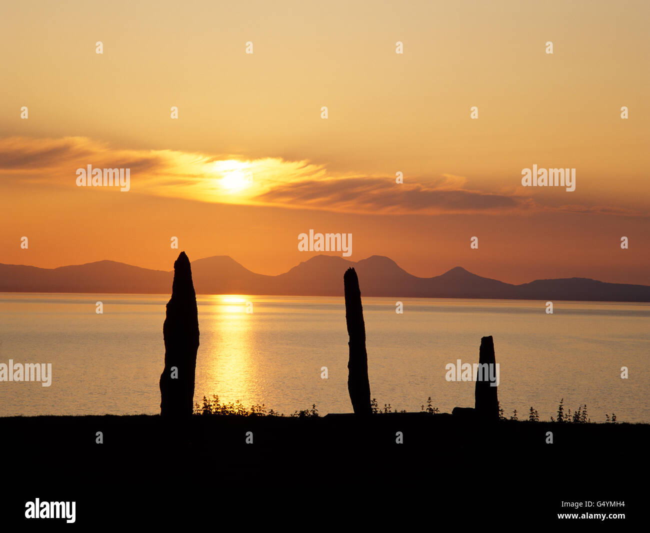 Ballochroy Menhire Mittsommer Sonnenuntergang über Gigha Sound in Richtung Paps of Jura betrachten. Kintyre, Scotland, UK Stockfoto