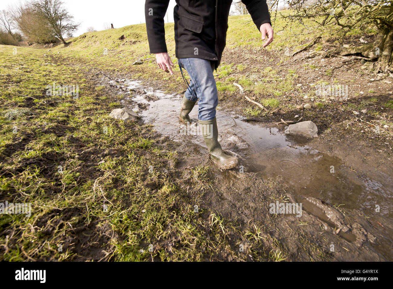 Simon Evans von Thames Water wandert auf einem kleinen schlammigen Fleck, wo der Fluss Kennet normalerweise entlang Feldern in der Nähe des Dorfes Lockeridge, westlich von Marlborough, fließt. Stockfoto