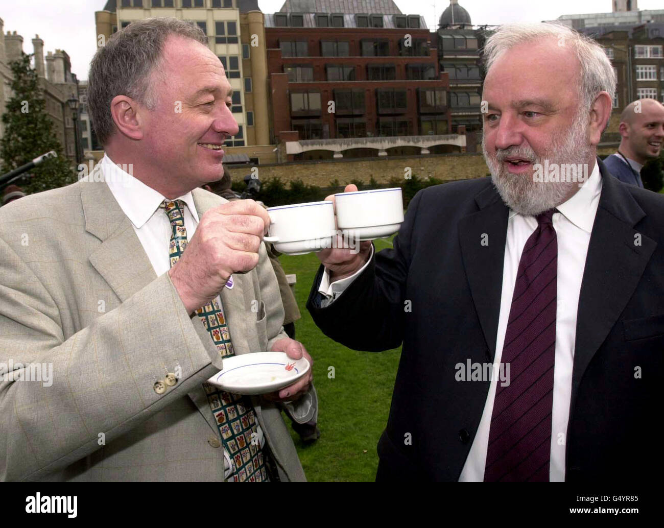 Die Londoner Bürgermeister-Kandidaten Frank Dobson (rechts) und Ken Livingstone genießen eine Tasse Kaffee in London. Die Rivalen fuhren im gebundenen Heißluftballon der Cancer Research Campaign auf dem Gelände des Armoury House der Honourable Artillery Company. *um Geld für die Krebsforschung zu sammeln. Stockfoto