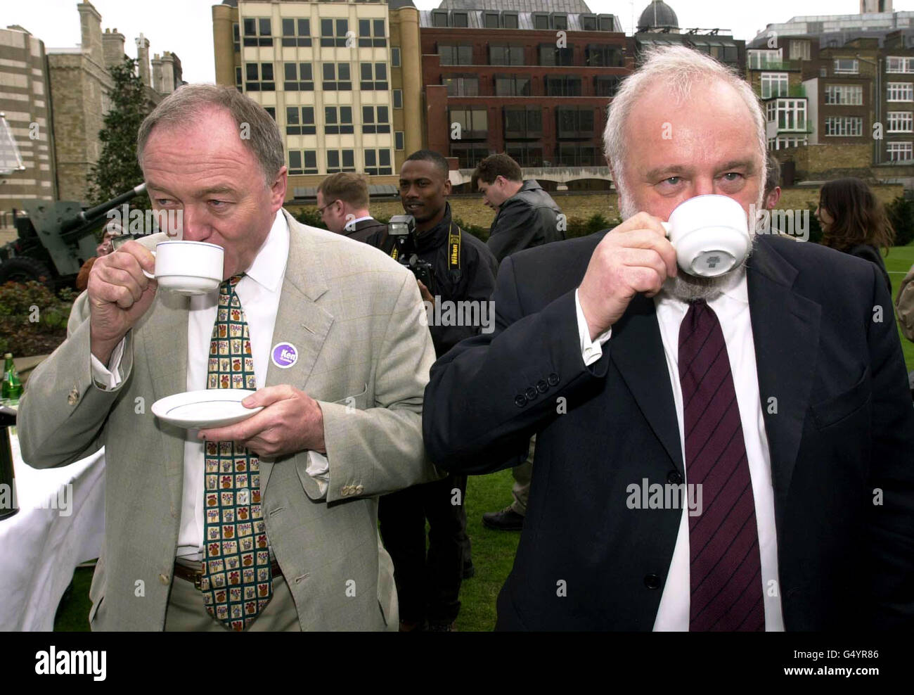 Die Londoner Bürgermeister-Kandidaten Frank Dobson (rechts) und Ken Livingstone genießen eine Tasse Kaffee in London. Die Rivalen fuhren im gebundenen Heißluftballon der Cancer Research Campaign auf dem Gelände des Armoury House der Honourable Artillery Company. *um Geld für die Krebsforschung zu sammeln. Stockfoto