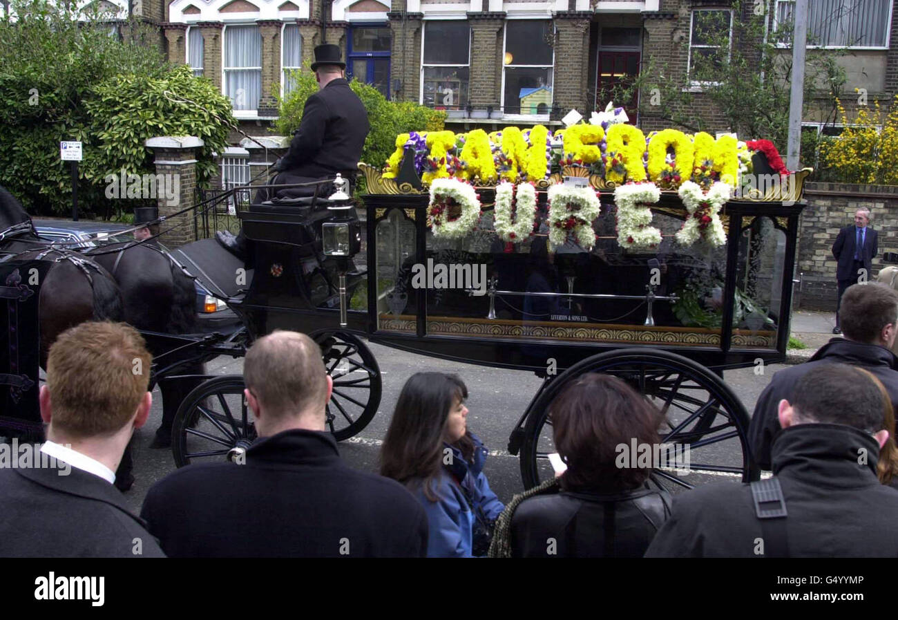 Ein traditionelles Pferd und Kutsche mit dem Sarg von Popstar Ian Dury, führte die Beerdigung Cortege. Über dem Sarg lagen Blumen mit den Worten 'Ian von Durex'. * andere Blumen auf dem Leichenwagen stammten von der Band Madness, die eine Nachricht mit der Aufschrift 'Onkel Ian von Madness' schickte. Andere Blumen sagten 'Oi Oi', 'Dad' und 'Durex', letztere ein Stück auf Ian Durys Namen. Die Prozession verließ den Belsize Park im Norden Londons und ging innerhalb von einer halben Meile an der Kilburn High Road vorbei, die seiner ersten Band ihren Namen gab. Dury starb letzte Woche im Alter von 57 Jahren, nach einem langen Kampf mit Krebs. Stockfoto