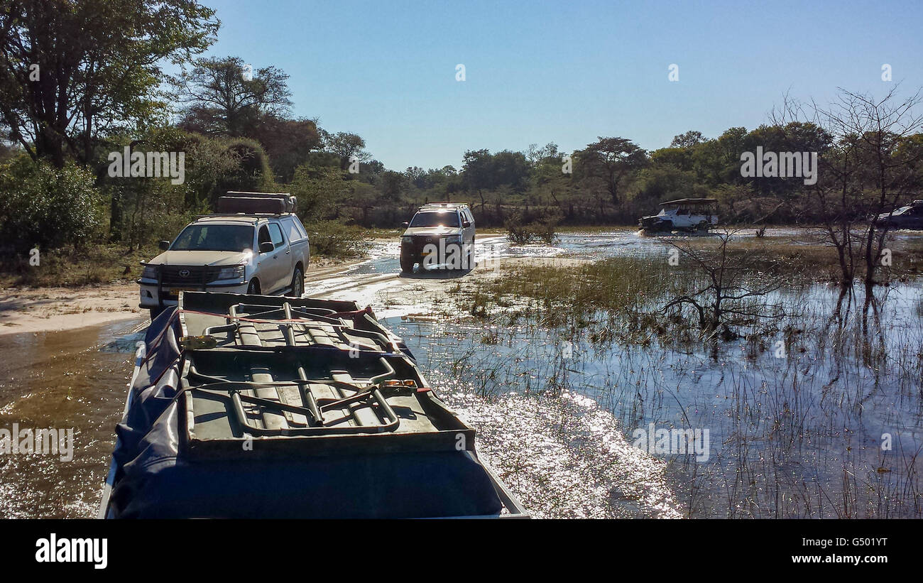 Botswana, Fahrt zum Okavango Delta, Safari, mehrere Jeeps fahren durch Wasser Stockfoto
