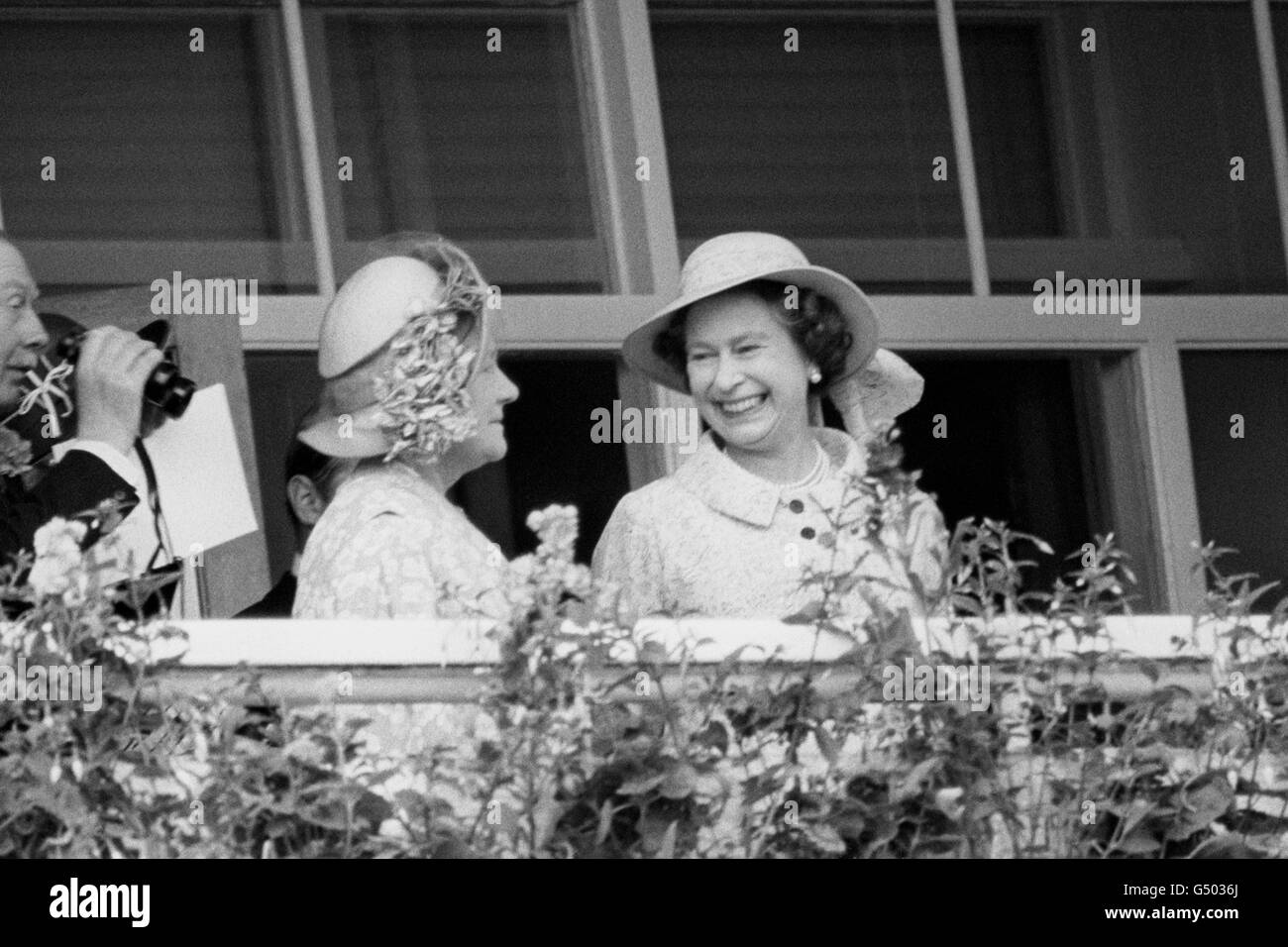Die Königin kichert mit der Königin Mutter, während sie die Aktion aus der Royal Box beobachten. Stockfoto