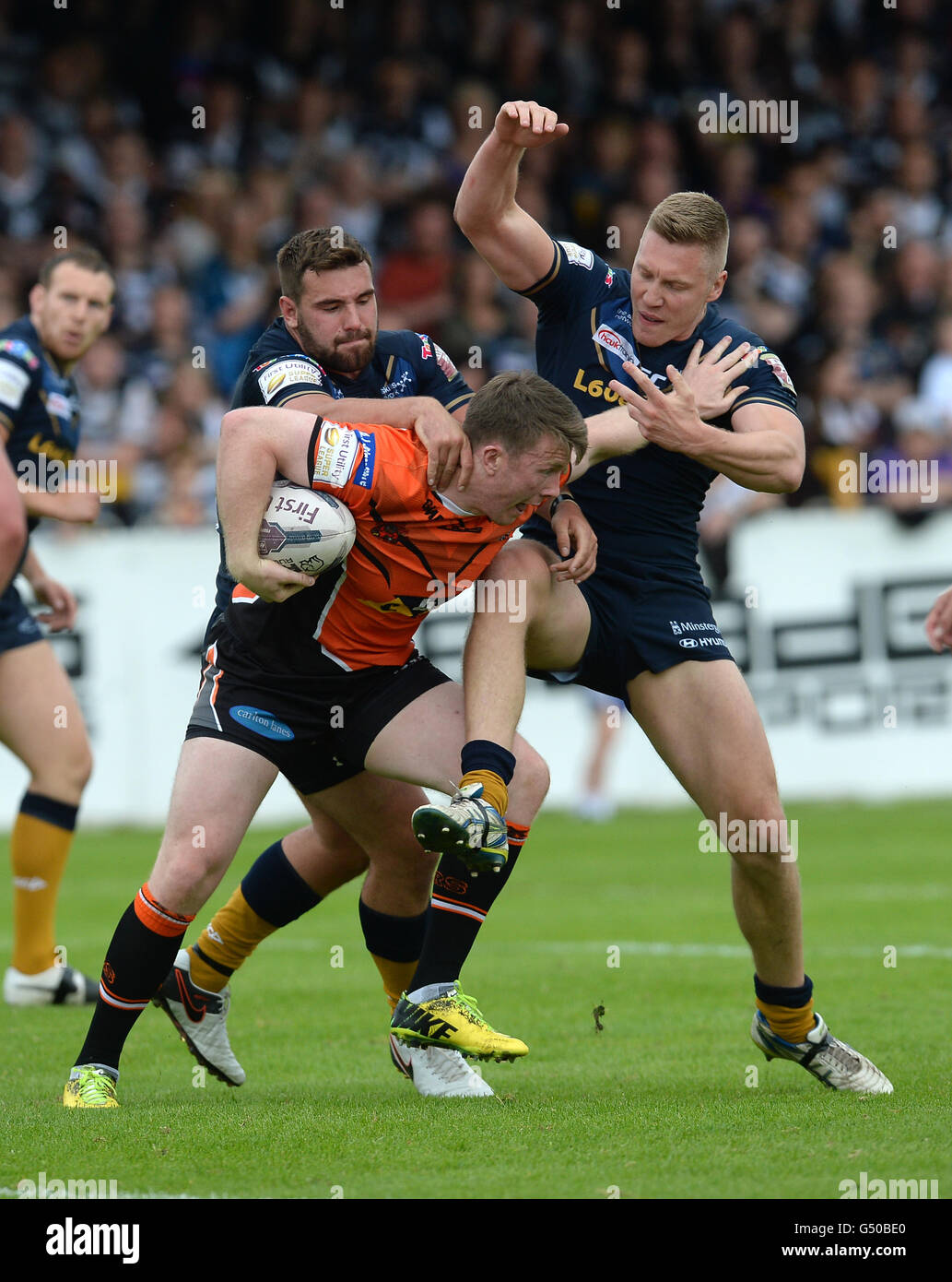 Castleford Tigers' Paddy Flynn von Hull FC Josh Bowden (links) und Chris Green während der Super-League-Spiel auf dem Weg der Besserung-A-Schlauch Dschungel, Castleford in Angriff genommen wird. Stockfoto