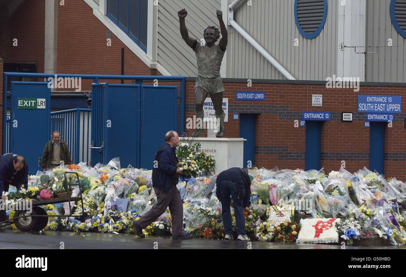 Am Morgen des UEFA-Cup-Spiels zwischen Leeds und Galatasaray entfernen die Stewards die Blumen, die zu Ehren der beiden in der Türkei getöteten Fans im Stadion der Elland Road gelegt wurden, und stellen sie an die Füße der Statue des legendären Spielers des Clubs, Billy Bremner. *die Sicherheit am Boden und um den Boden herum wird eng, nachdem zwei Leeds-Fans vor dem ersten Teilstück des Unentschieden in Istanbul erstochen wurden. Stockfoto