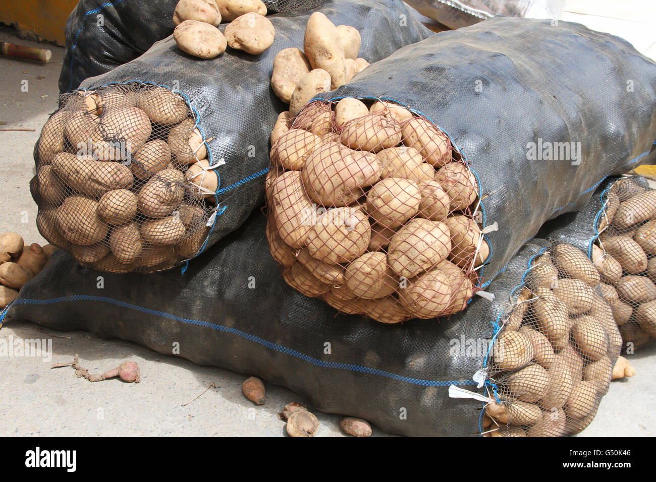 Vier große Säcke mit gelben Kartoffeln auf einem Bauernmarkt in Peru Stockfoto