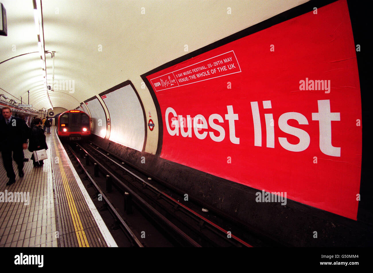 Eine U-Bahn-Station der Londoner U-Bahn fährt am Oxford Circus, London, entlang der Westbound-Plattform der Central Line, vorbei an 23 Postern für das BBC Music Live Festival. BBC stellte die neue Reihe von Postern mit dem Titel Guest List vor, auf denen fast alle in Großbritannien vertreten waren. * Es soll das Festival fördern, das vom 25. Bis 29. Mai stattfindet. Stockfoto