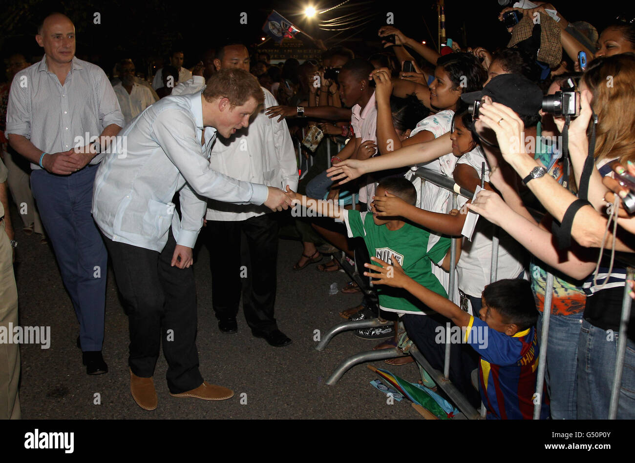 Prinz Harry trifft Einheimische bei einem Rundgang auf einer "Block Party" im neu benannten Queen Elizabeth II Boulevard, in der Hauptstadt Belmopan, Belize, Mittelamerika, besucht der Prinz Belize im Rahmen einer Diamond Jubilee Tour, wo er Belize, die Bahamas, Jamaika und Brasilien als Vertreter der Königin Elizabeth II.. Stockfoto