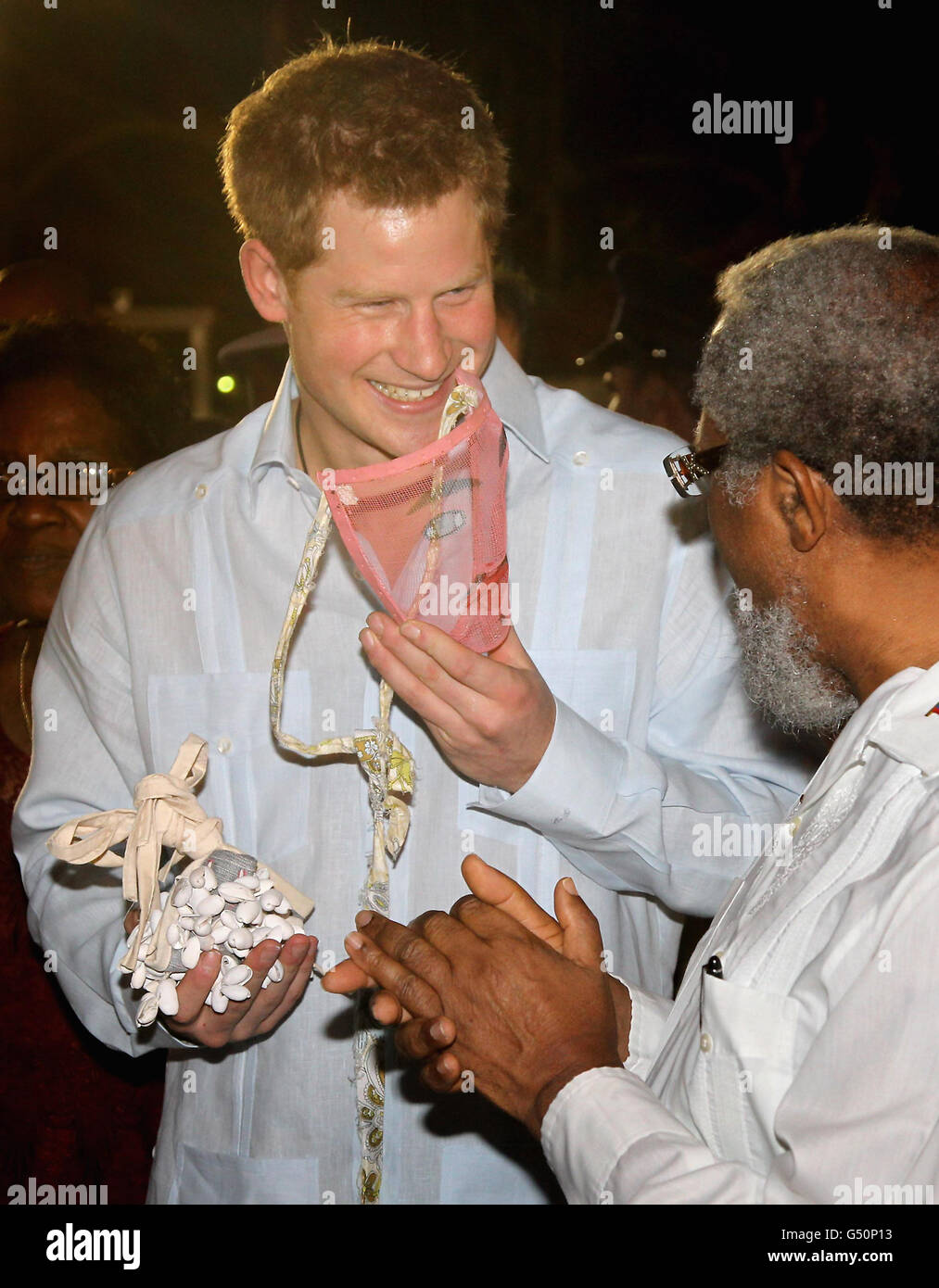 Prinz Harry probiert eine Maske an, während er an einem traditionellen Tanz während eines Spaziergehens auf einer „Blockparty“ im neu benannten Queen Elizabeth II Boulevard in der Hauptstadt Belmopan, Belize, Mittelamerika, teilnimmt. Der Prinz besucht Belize im Rahmen einer Diamond Jubilee Tour, wo er Belize, die Bahamas, Jamaika und Brasilien als Vertreter von Königin Elizabeth II. Besuchen wird Stockfoto