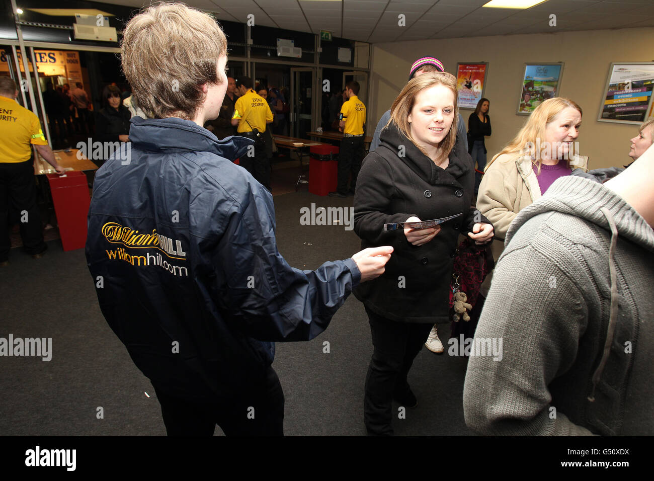 Darts - McCoys Premier League Darts 2012 - Westpoint Arena. Mitarbeiter von William Hill verteilen Flugblätter, während die Dartfans in der Arena ankommen Stockfoto