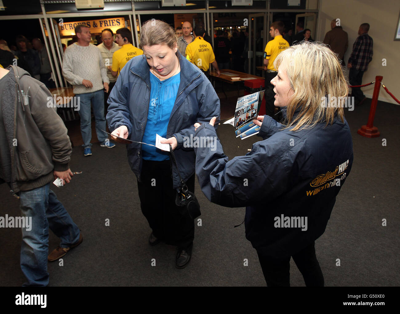 Darts - McCoys Premier League Darts 2012 - Westpoint Arena. Mitarbeiter von William Hill verteilen Flugblätter, während die Dartfans in der Arena ankommen Stockfoto