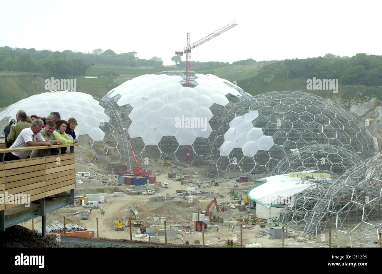 Besucher am ersten Tag der offenen Tür des Eden Project in Bodelva, in der Nähe von St. Austell, Cornwall, als die Besucher den britischen Garten Eden betraten, ein riesiges futuristisches Gewächshaus, das sich in den Eingeweiden einer stillgelegt Tongrube formt. * die Biomes (unten) werden aus 1,000 Tonnen leichten Stahlpaneelen gebaut und werden 10,000 Pflanzenarten beherbergen, die das 74 Millionen Eden Project bilden werden. Stockfoto