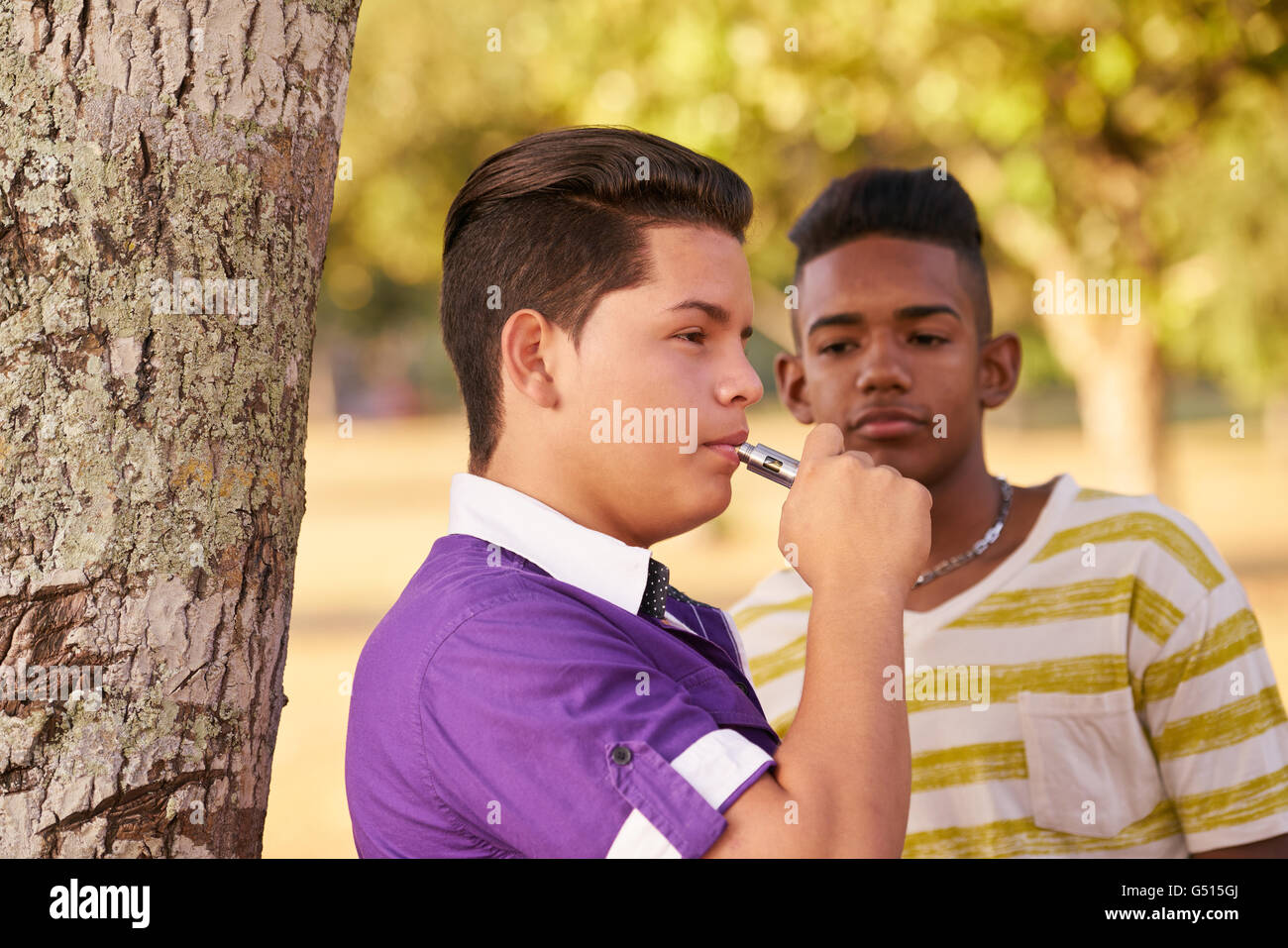 Kinder im Park rauchen elektronische Zigarette. Konzept der Raucher- und soziale Probleme mit Teenagern Stockfoto