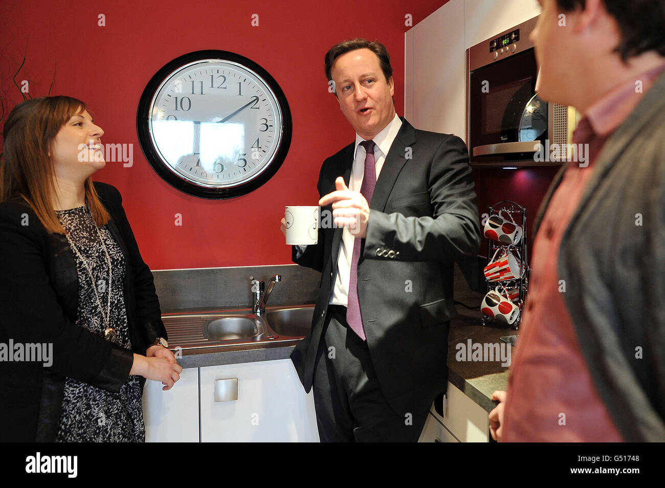 Premierminister David Cameron spricht mit einem jungen Paar, Lianne Cowdry , 27 und Neil Henderson , 29, während eines Besuchs in einer Barratt Homes Development Show-Wohnung, um Paare zu treffen, die das NewBuy-Programm in Lewisham nutzen wollen. Stockfoto