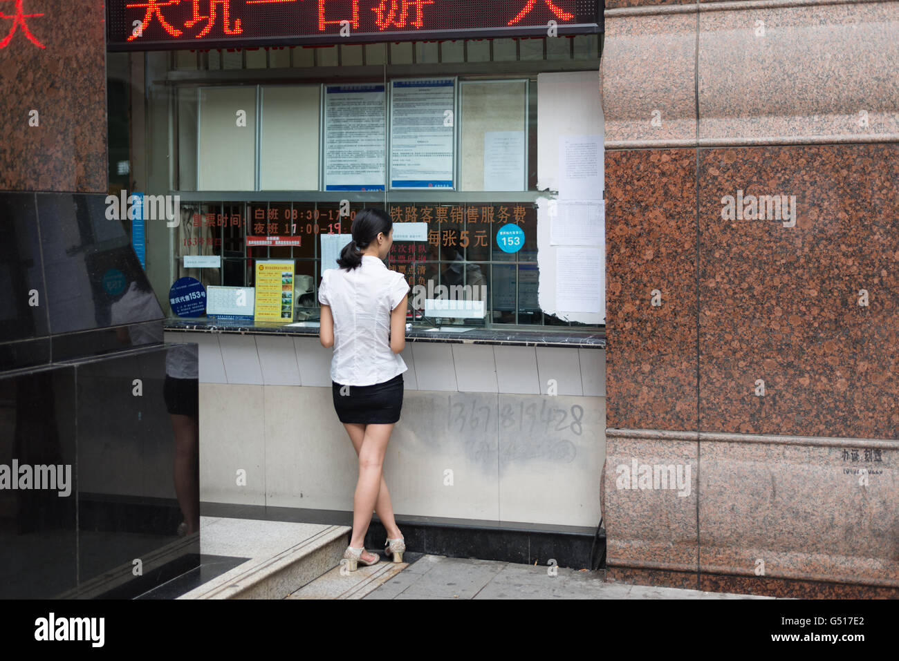 China, Chongqing, Frau stand am Ticketschalter Stockfoto