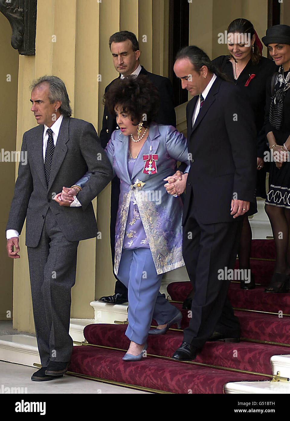 Dame Elizabeth Taylor wird von ihrer Familie begleitet, als sie den Buckingham Palace verlässt, nachdem sie von der britischen Königin Elizabeth II. Bei einer Zeremonie im Buckingham Palace, London, die Ehre der Kommandantin des britischen Ordens erhalten hat. Stockfoto