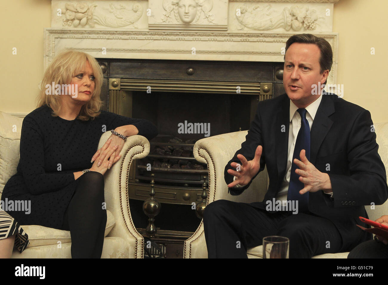 Prime Minster David Cameron sitzt neben der Schauspielerin Sherrie Hewson bei einem Treffen mit Aktivisten in der Downing Street, London, 10 im Rahmen des Internationalen Frauentags. Stockfoto