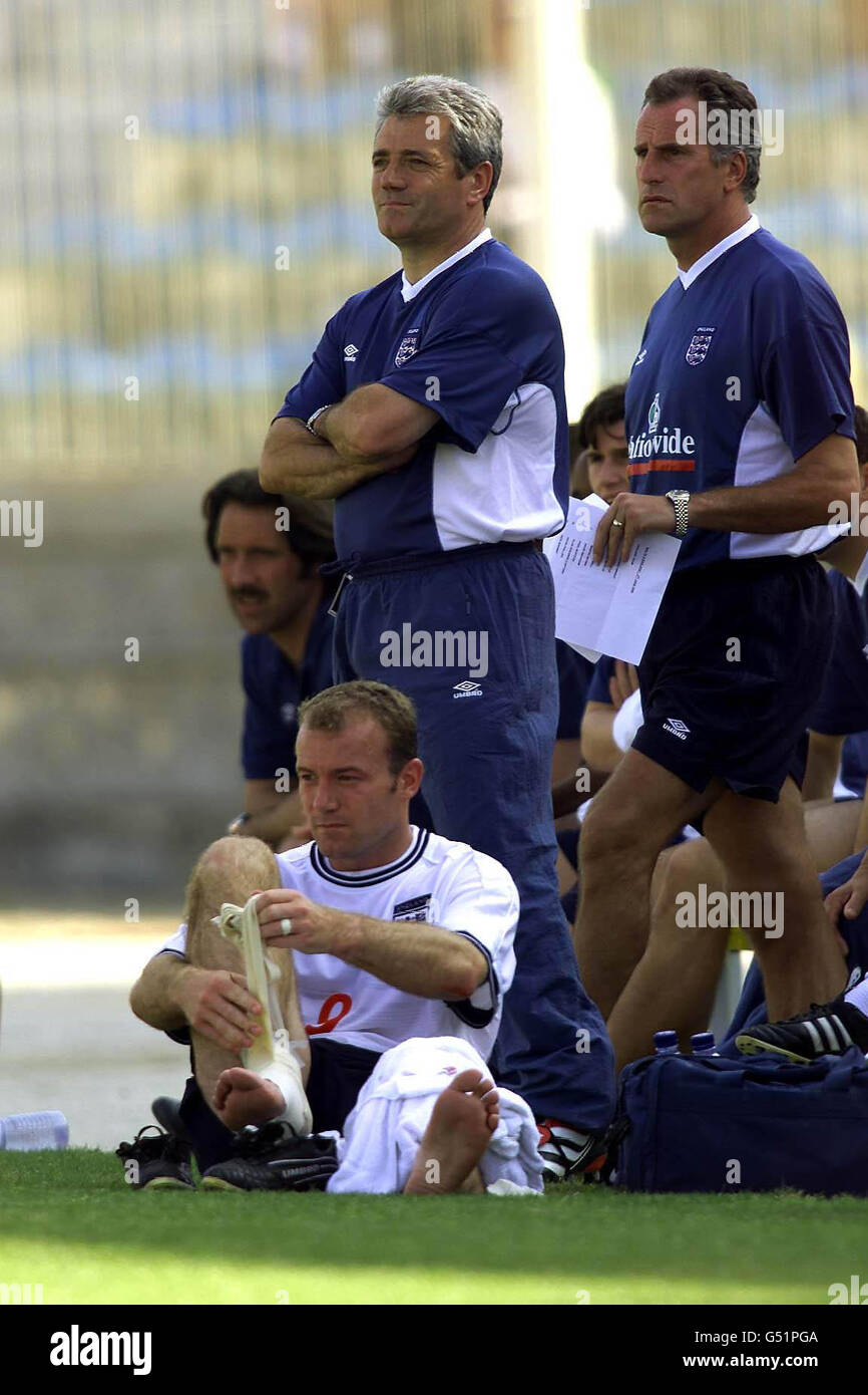 Dieses Bild darf nur im Rahmen eines redaktionellen Features verwendet werden. Der englische Kapitän Alan Shearer (links unten) entfernt das Band von seinem rechten Knöchel, nachdem er während des internationalen Freundschaftsspiel gegen Malta in Valletta ersetzt wurde. * ... im Nationalstadion von Malta. Manager Kevin Keegan (links stehend) beobachtet das Spiel. Stockfoto