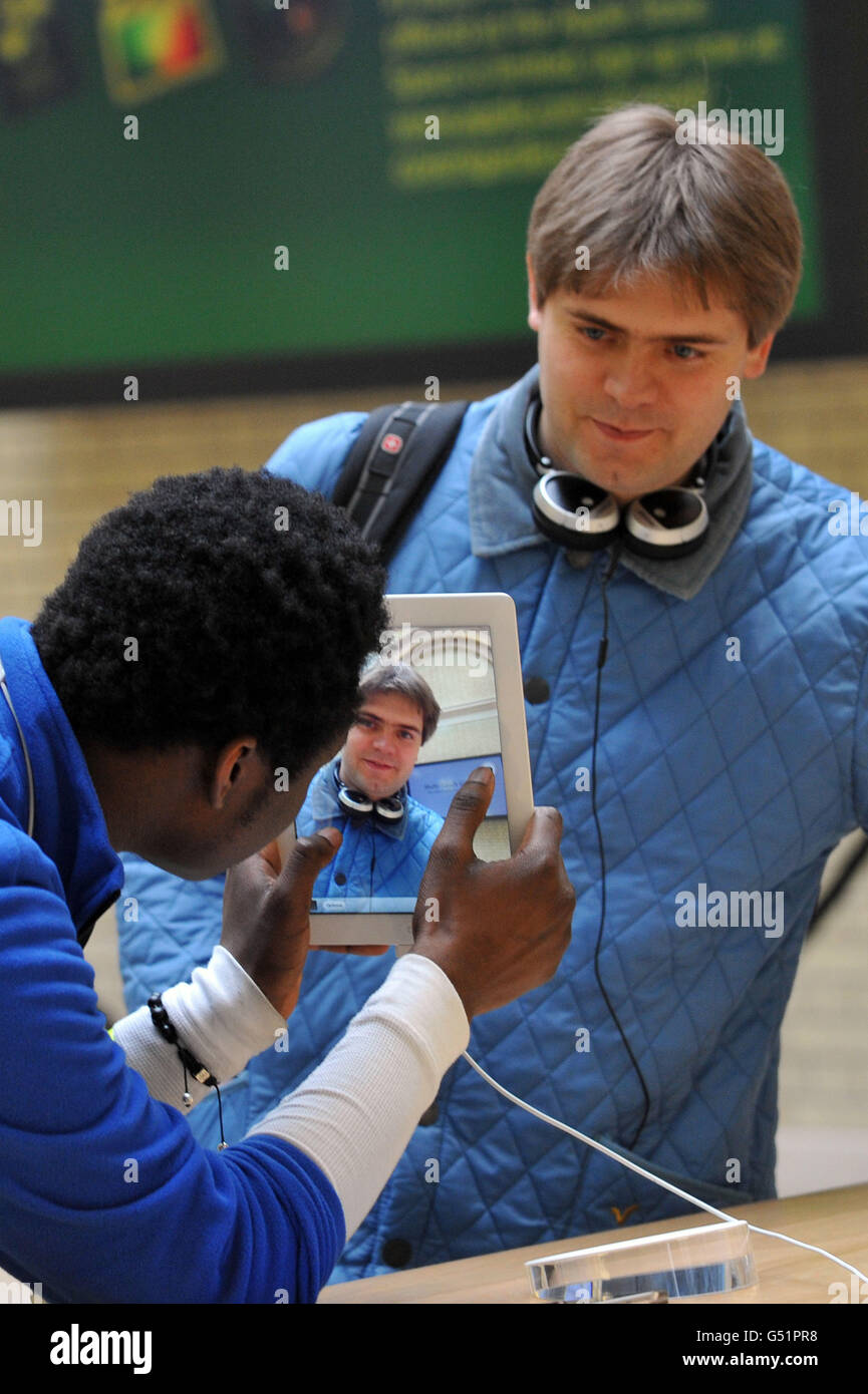 Ein Mitarbeiter von Apple demonstriert einem Kunden das neue iPad 3 im Covent Garden Store des Unternehmens mit der Veröffentlichung der neuesten Version des Tablet-Computers. Stockfoto