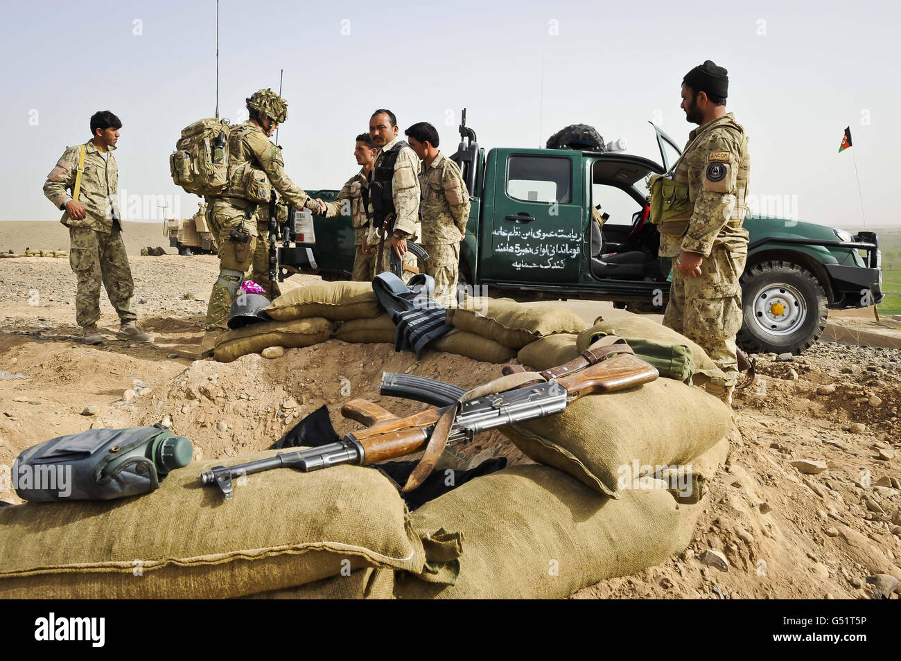 Der zweite Leutnant Chris Trezise (zweiter links) vom 1. Bataillon, dem Royal Regiment der Prinzessin von Wales, begrüßt die afghanische Polizei der Nationalen Zivilordnung (ANCOP), die an einem Beobachtungspunkt in der Region Yakchal über die Operation „Now Roz“ (New Day in in Dari), Die Afghan National Security Force (ANSF) befreit die Taliban aus den von britischen Streitkräften unterstützten und betreuten Gebieten Gereshk und Lashkar gar in der Provinz Helmand, was als die letzte kombinierte Operation gilt, um die traditionell eine Taliban-Hochburg vom Aufstand zu befreien. Stockfoto