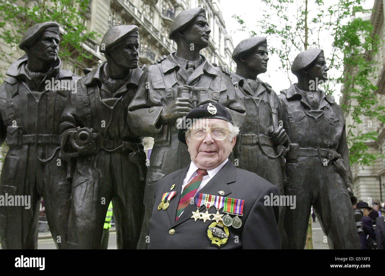 Bill Bourne, 78, der im Zweiten Weltkrieg in Nordafrika in Panzern diente, steht vor einer Bronzestatue einer fünfköpfigen Panzerbesatzung, die Queen Elizabeth II. Am Whitehall Place, London, enthüllt hat. * die Gedenkstatue ist den Männern des Königlichen Panzerregiments gewidmet, das vor 100 Jahren am 13/06/00 gegründet wurde. Die Königin wurde von einem Panzerwagen von Rolls-Royce aus dem Jahr 1924 vom Buckingham Palace zur Statue begleitet. Stockfoto