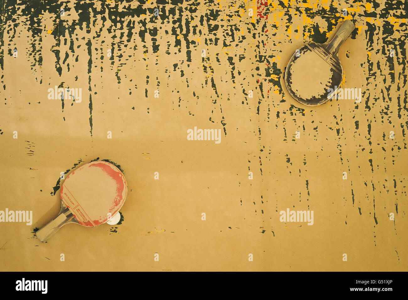 Tischtennisschläger liegen in einem Erholungsgebiet der ISAF Main Operation Base Lashkar gar in einem staubigen Talkumpuder auf einer Tischtennisplatte, nachdem ein 24-stündiger Sandsturm das Gebiet der Provinz Helmand in Afghanistan getroffen hatte und die ungestörten Gebiete in Wüstenfarbe dargestellt hatte. Stockfoto