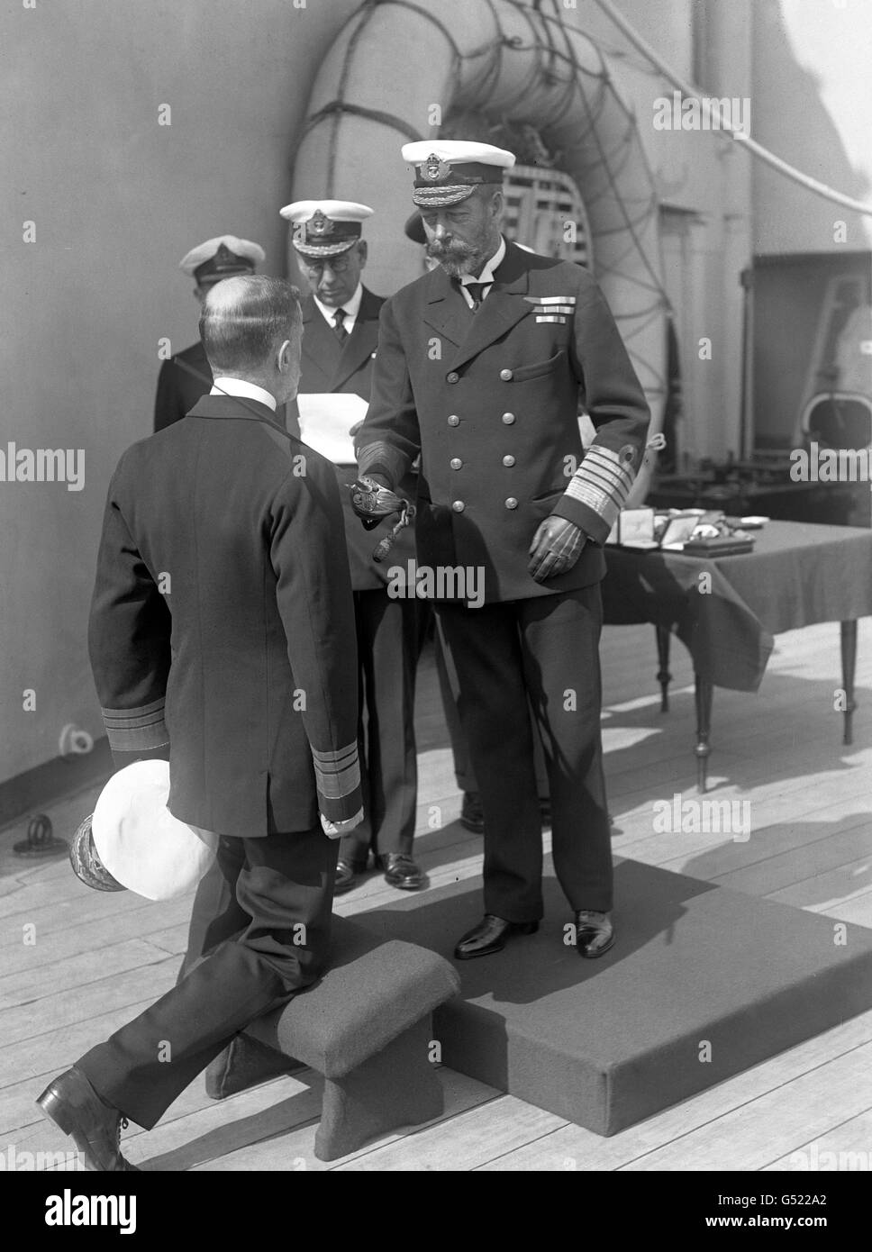 König George V. verleiht dem Vizeadmiral Pakenham an Bord der HMS Princess Royal, um 1927, eine Ritterschaft. Stockfoto