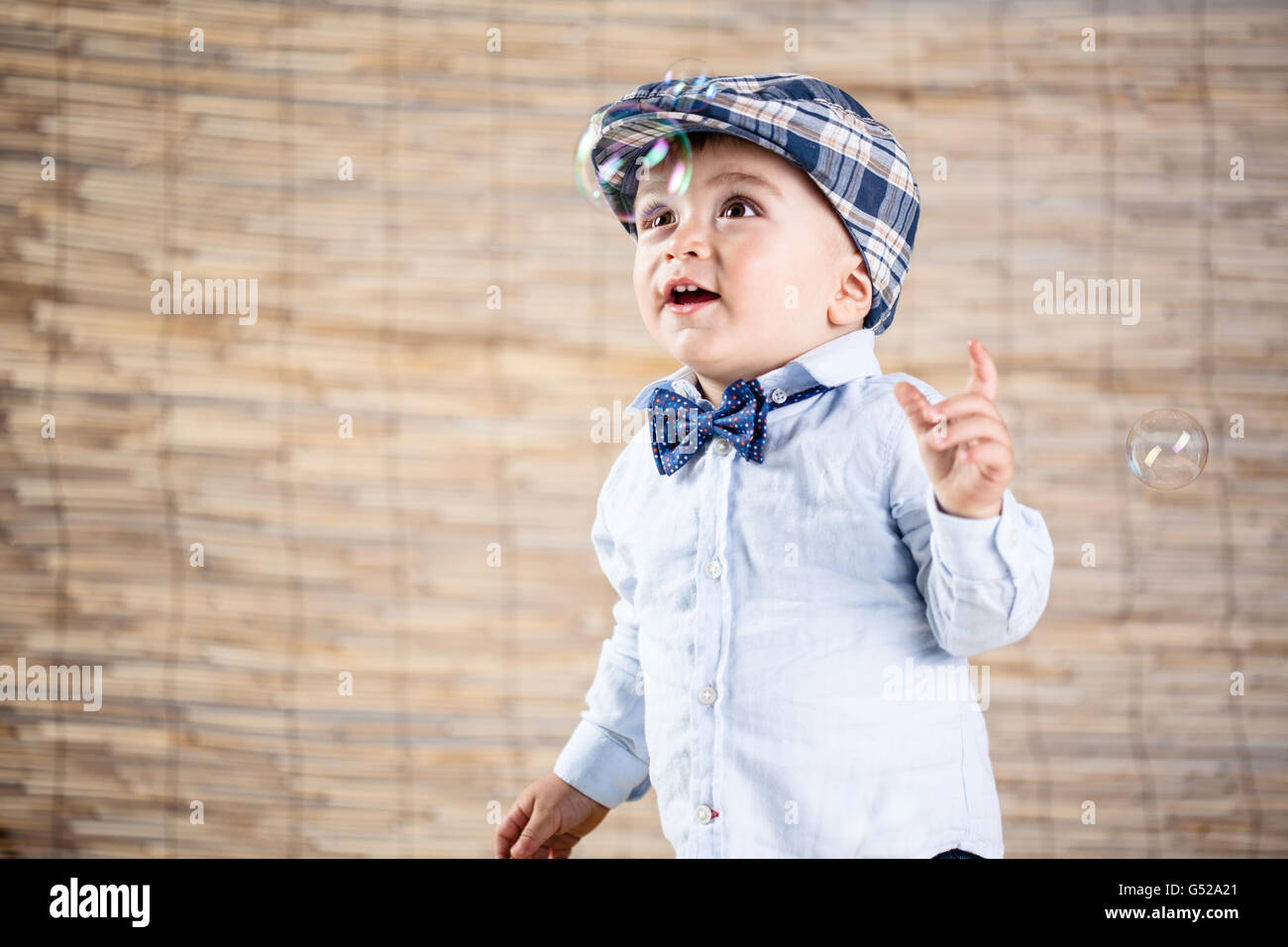 Baby Boy mit Gentleman-Outfit auf Bambus-Hintergrund Stockfoto