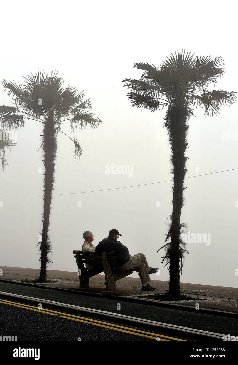 Ein Paar sitzt auf einer Nebelbank am Meer und wartet darauf, dass die vorhergesagte Hitzewelle am Wochenende Southend-on-Sea, Essex, erreicht. Stockfoto